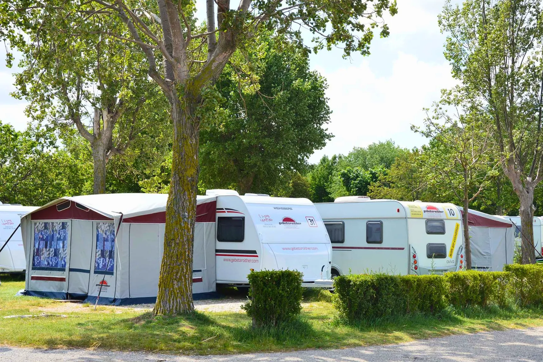 Wohnwägen unter im Schatten unter Bäumen am Camping Resort Turnersee